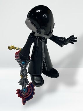 Black Hooded Figure Vinyl Collectible with Ornate Keyblade